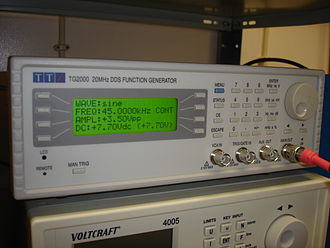 A DDS function generator on a laboratory bench, front panel showing controls and display