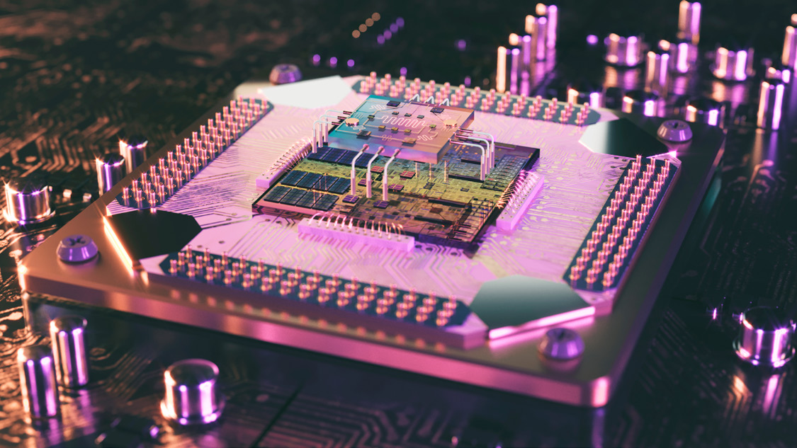 Photograph of a physical quantum processor chip mounted in packaging, lit with pink and purple light