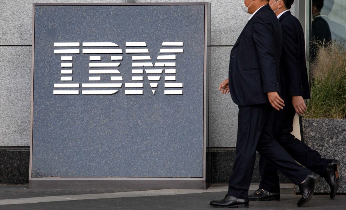 A passerby walks past an IBM logo at a corporate site.
