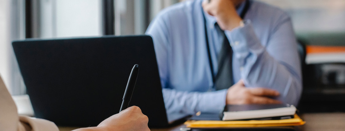 A candidate taking notes during a hiring conversation