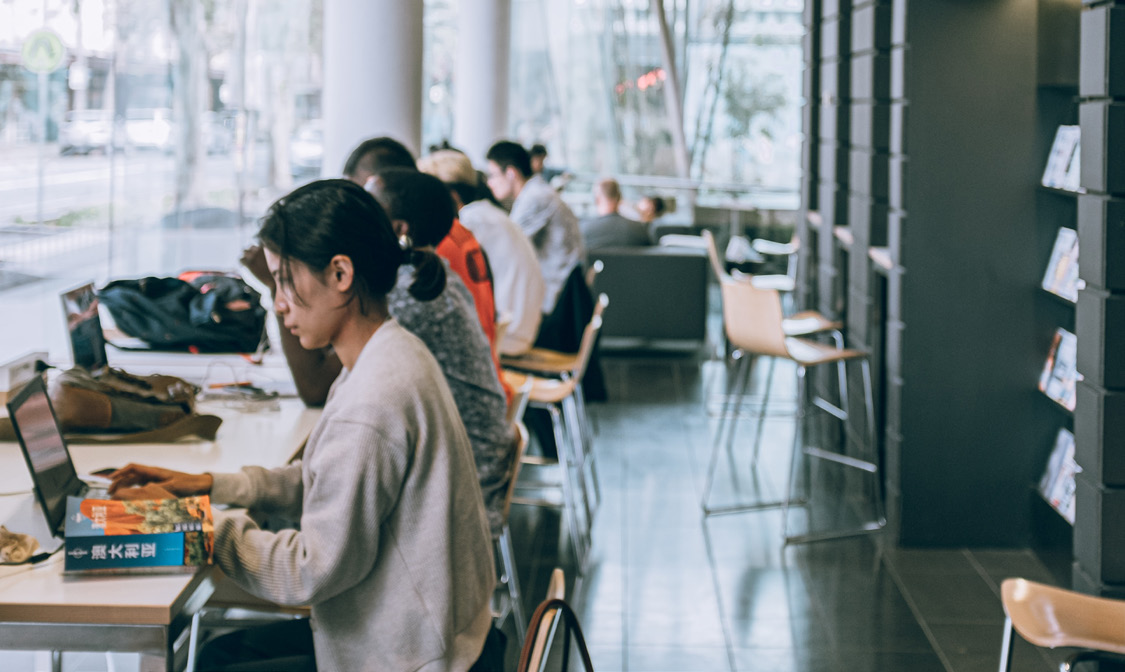 Researchers and students working at laptops in a shared study space