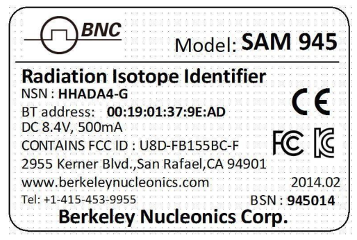 SAM 945 rear label showing radiation isotope identifier model, power requirements, FCC ID, and BSN serial number